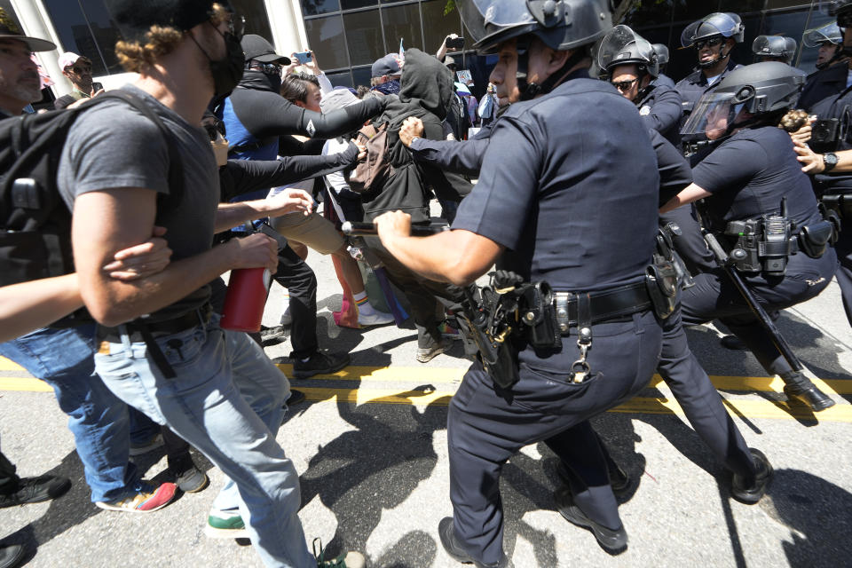 Los Angeles police officers clash with counter demonstrators supporting LGBT rights during a Parents Rights protest outside the Los Angeles Unified School District headquarters in Los Angeles, Tuesday, Aug. 22, 2023. (AP Photo/Damian Dovarganes)