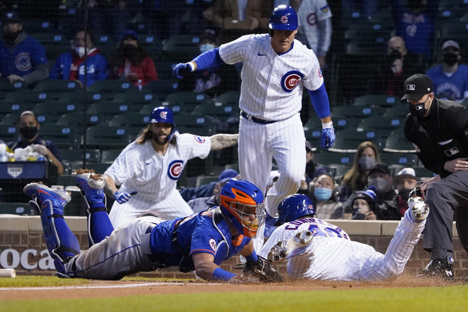 Chicago Cubs' Willson Contreras, front right, is safe at home plate as New York Mets catcher James McCann, front left, makes a late tag during the third inning of a baseball game, Thursday, April, 22, 2021, in Chicago. (AP Photo/David Banks)