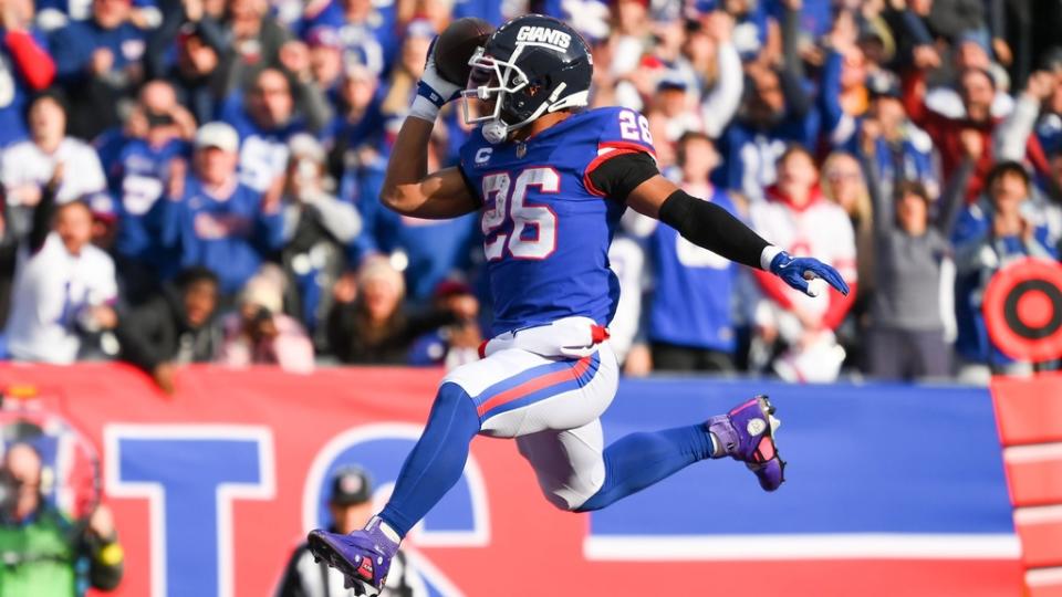 Dec 4, 2022; East Rutherford, New Jersey, USA; New York Giants running back Saquon Barkley (26) leaps into the end zone for a touchdown against the Washington Commanders during the first half at MetLife Stadium.