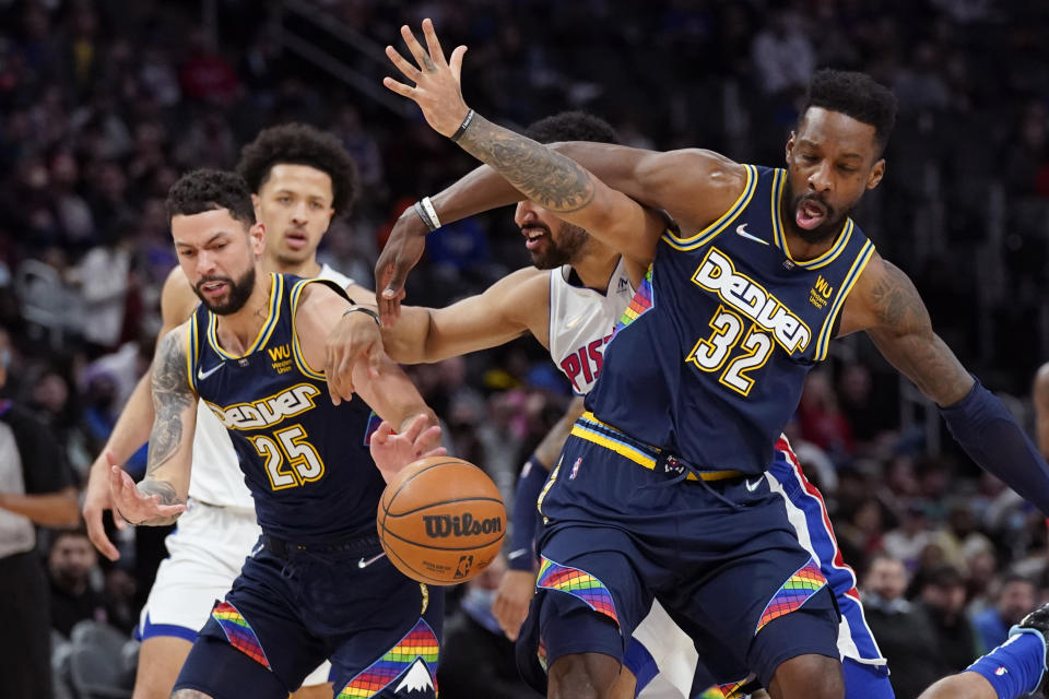 Detroit Pistons forward Trey Lyles loses control of the ball as he runs into Denver Nuggets guard Austin Rivers (25) and forward Jeff Green (32) during the second half of an NBA basketball game, Tuesday, Jan. 25, 2022, in Detroit. (AP Photo/Carlos Osorio)