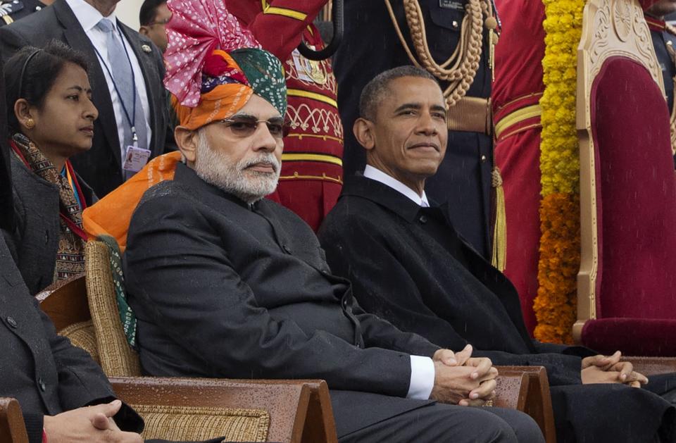 India's Prime Minister Modi and U.S. President Obama sit under umbrellas watching India's Republic Day parade in the rain together from their review stand in New Delhi