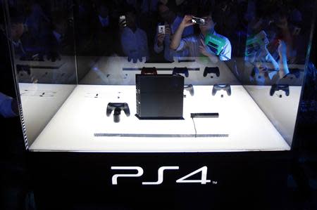 Visitors take pictures of Sony Corp's PlayStation 4 new game console at the Tokyo Game Show in Chiba, east of Tokyo, in this September 19, 2013 file photo. REUTERS/Yuya Shino/Files