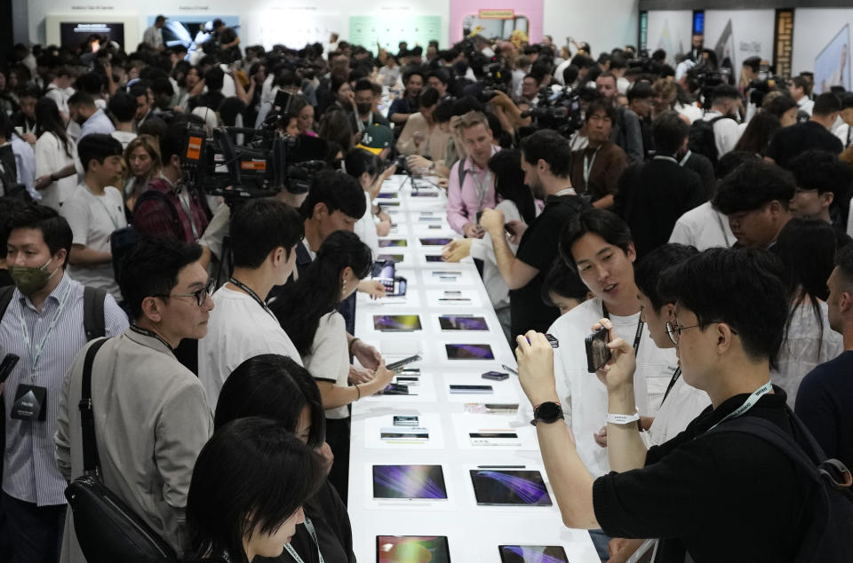 People look at products during the Galaxy Unpacked 2023 event at the COEX in Seoul, South Korea, Wednesday, July 26, 2023. Samsung Electronics on Wednesday unveiled two foldable smartphones as it continues to bet on devices with bending screens, a budding market that has yet to fully take off because of high prices. (AP Photo/Ahn Young-joon)