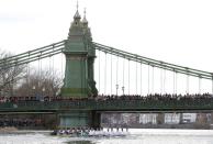 FILE PHOTO: Spectators crowd Hammersmith Bridge to watch Oxford University's 8 pull past Cambridge's rowing team in the Boat Race on the River Thames in London