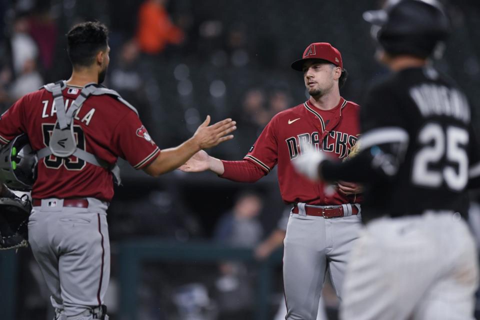 Arizona Diamondbacks closing pitcher Kyle Nelson celebrates with catcher Seby Zavala (59) after the team's win over the Chicago White Sox in a baseball game Tuesday, Sept. 26, 2023, in Chicago. (AP Photo/Paul Beaty)