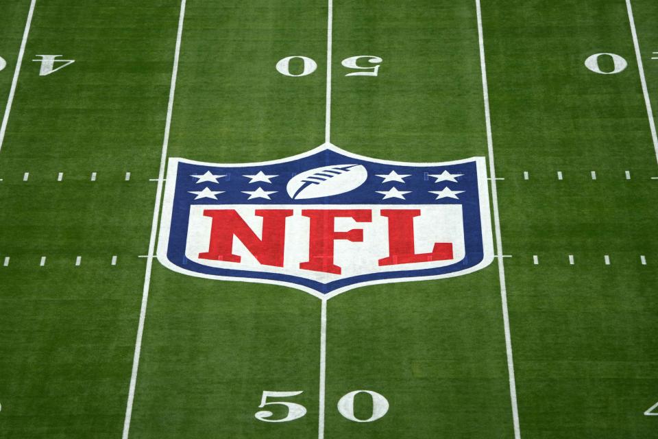A NFL shield logo at midield of Super Bowl 57 at State Farm Stadium.