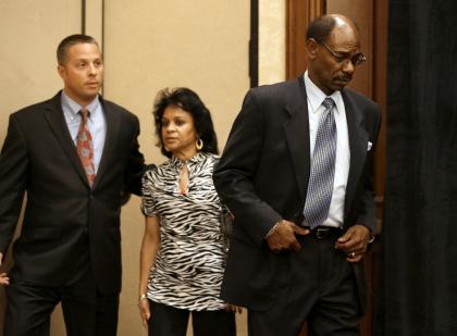 Ron Washington, right, arrives at Thursday's news conference followed by wife Gerry. (AP)