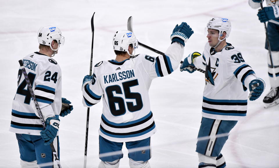 San Jose Sharks' Erik Karlsson (65) celebrates after his goal against the Winnipeg Jets with Jacob Peterson (24) and Logan Couture (39) during third-period NHL hockey game action in Winnipeg, Manitoba, Monday April 10, 2023. (Fred Greenslade/The Canadian Press via AP)