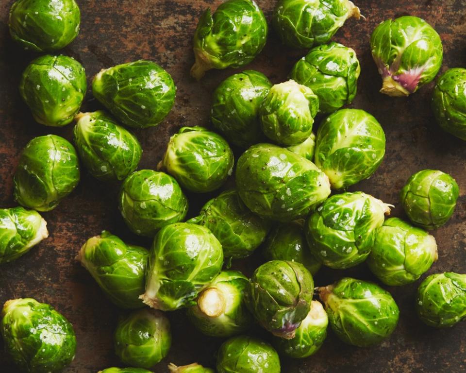 Several bright-green brussels sprouts in a pan.