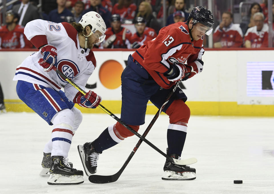 Washington Capitals Jakub Vrana (13), of the Czech Republic, eyes the puck under pressure from Montreal Canadiens Jonathan Drouin (92) during the second period of their NHL hockey game in Washington, Thursday, April 4, 2019. (AP Photo/Susan Walsh)