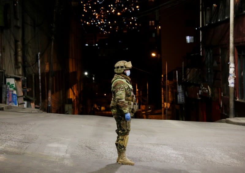 A Bolivian military officer stands on a street in the empty city centre of La Paz