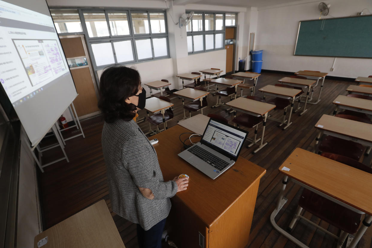 An unidentified teacher gives an online class amid the new coronavirus outbreak at Seoul girls' high school in Seoul, Thursday, April 9, 2020. Senior high school students begin school semester with online classes.  Schools remain closed as part of measures taken by the government to stop the spread of the coronavirus. (AP Photo/Ahn Young-joon)