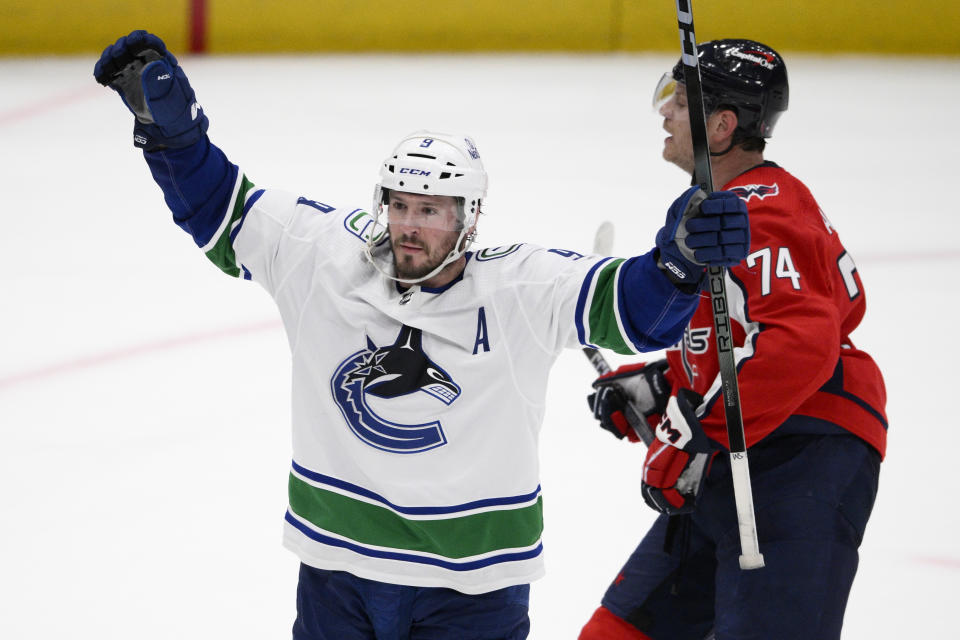 Vancouver Canucks center J.T. Miller (9) celebrates after his winning goal during overtime of an NHL hockey game in front of Washington Capitals defenseman John Carlson (74), Sunday, Feb. 11, 2024, in Washington. (AP Photo/Nick Wass)
