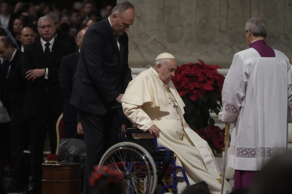 Pope Francis sits in a wheelchair as he presides over Christmas Eve Mass, at St. Peter's Basilica at the Vatican, Saturday Dec. 24, 2022. (AP Photo/Gregorio Borgia)