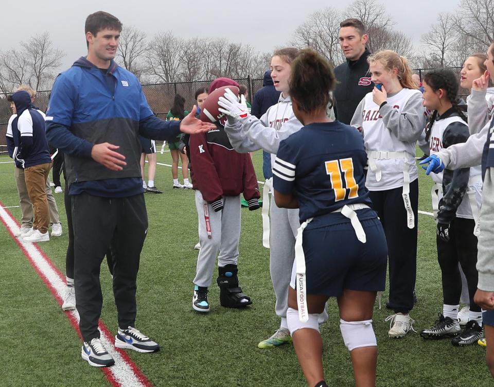 Giants quarterback Daniel Jones teaches some girls how to grip a football, during a kickoff event at Somers High School for the start of the first-ever girls flag football pilot program April 1, 2022. There are nine Section 1 teams participating in the program.