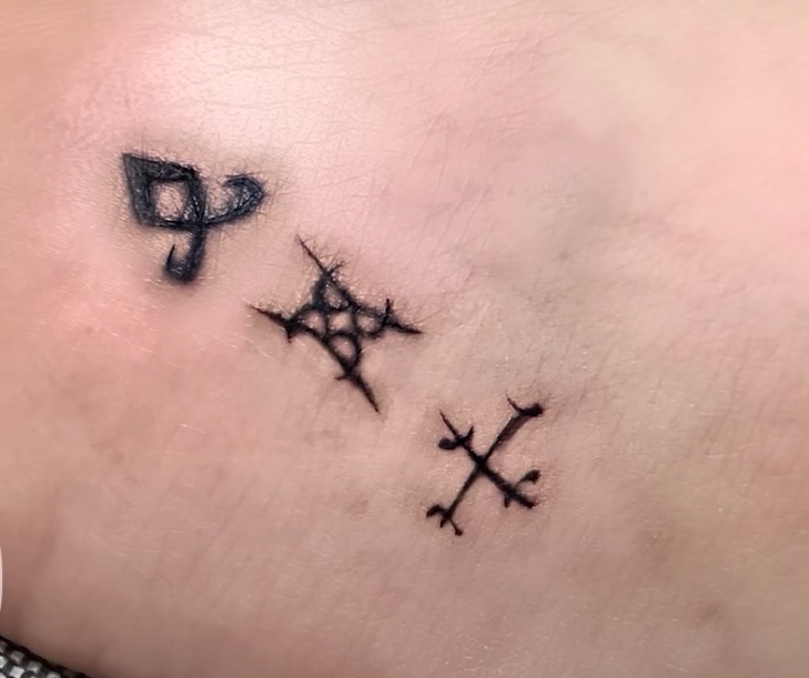 Kat's tattoos are three runes