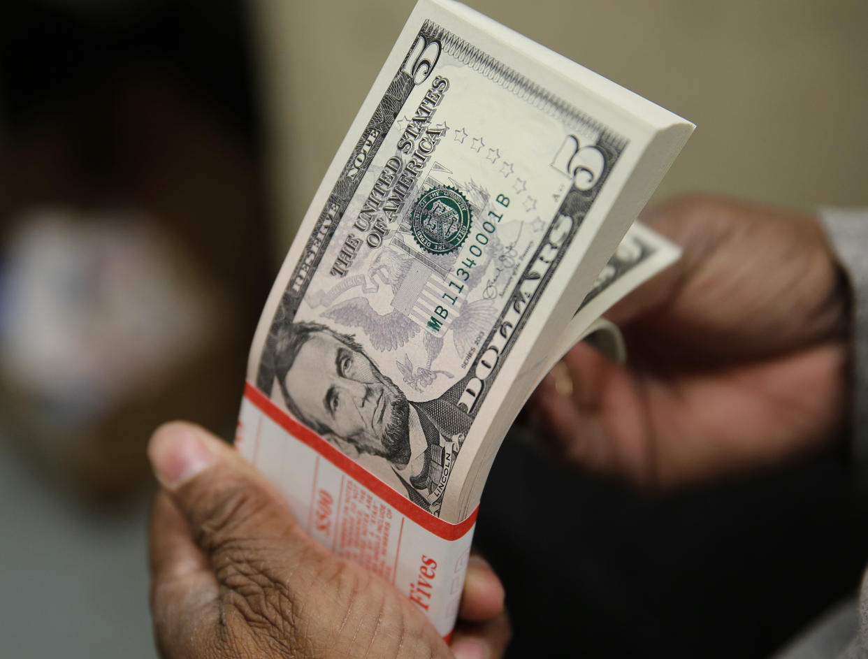 A packet  of former U.S. President Abraham Lincoln five-dollar bill currency is inspected at the Bureau of Engraving and Printing in Washington March 26, 2015. REUTERS/Gary Cameron/File Photo