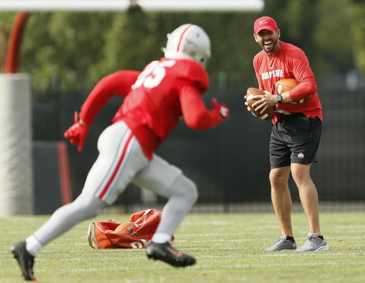 Ohio State Buckeyes wide receivers coach Brian Hartline works with Xavier Johnson (25) during football training camp at the Woody Hayes Athletic Center in Columbus on Tuesday, Aug. 10, 2021. 