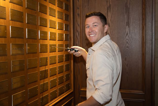 <p>Chris Hollo/Grand Ole Opry</p> Scotty McCreery screws in his nameplate at the Opry