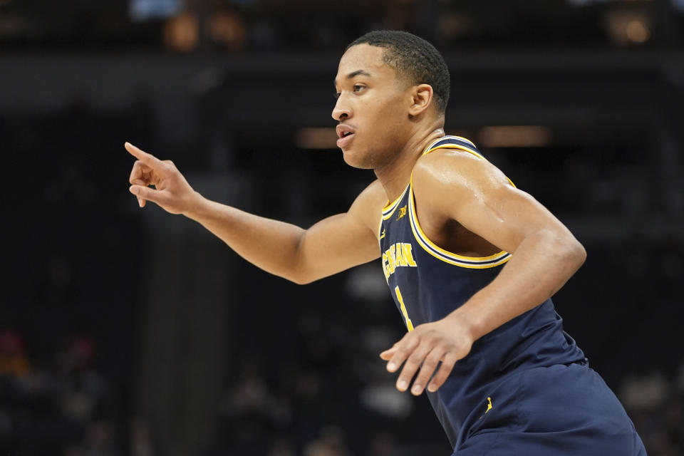 Michigan guard Nimari Burnett (4) points after making a 3-point basket against Penn State during the first half of an NCAA college basketball game in the first round of the Big Ten Conference men's tournament Wednesday, March 13, 2024, in Minneapolis. (AP Photo/Abbie Parr)