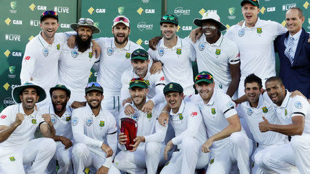 Cricket - Australia v South Africa - Third Test cricket match - Adelaide Oval, Adelaide, Australia - 27/11/16. South Africa's captain Faf du Plessis (C) holds the Test series trophy against Australia with team mates at the end of the Third Test cricket match. At right is former South African cricketer Kepler Wessels who presented du Plessis with the trophy. REUTERS/Jason Reed