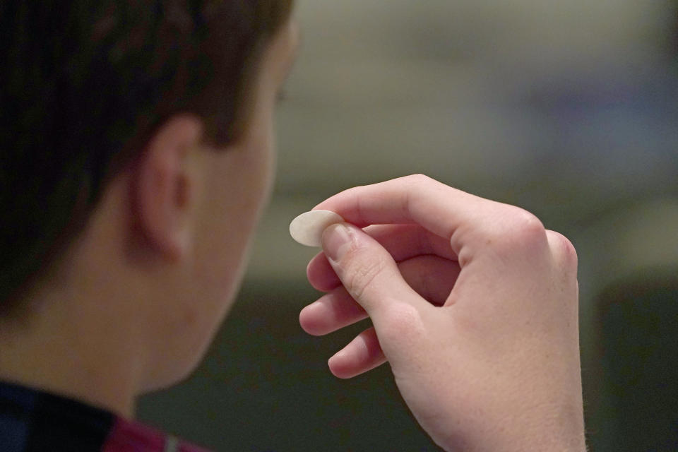 Cole McCorory, 15, prepares to receive a communion wafer during services at Highland Colony Baptist Church in Ridgeland, Miss., Nov. 29, 2020. The church practices covid protocols by allowing families to sit spaced out from others, separating older and more vulnerable members in the Worship Center and providing sanitizer and masks at the entrance. (AP Photo/Rogelio V. Solis)