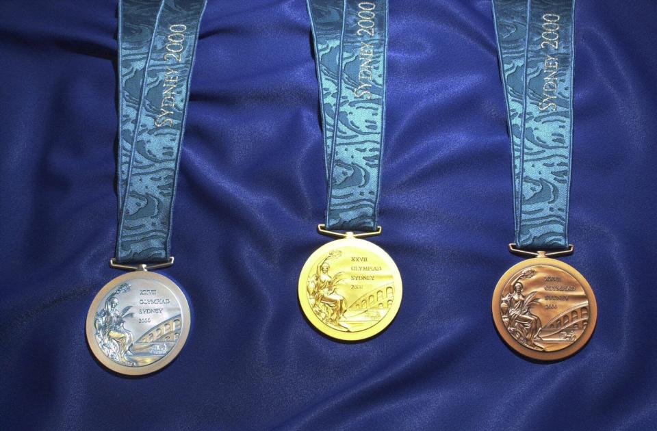 FILE - The silver, gold and bronze medals to be presented at the Sydney 2000 Olympics are put on show in Sydney, Saturday, August 12, 2000. (AP Photo/Rick Rycroft, File)