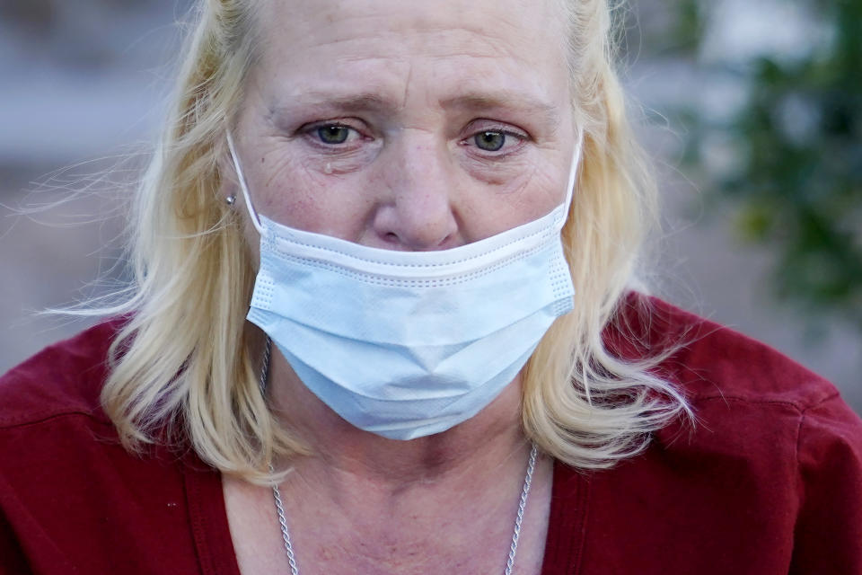 Karla Finocchio, 55, tears up as she talks about being a homeless woman on the streets, Monday, Jan. 24, 2022, in Phoenix. Finocchio is one face of America's graying homeless population, a rapidly expanding group of destitute and desperate people 50 and older suddenly without a permanent home after a job loss, divorce, family death or health crisis during a pandemic. (AP Photo/Ross D. Franklin)