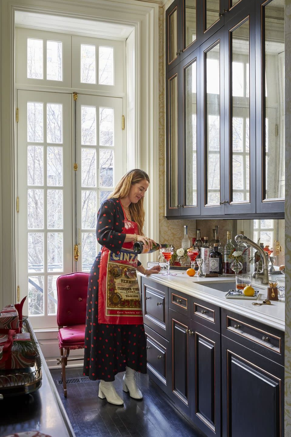 a person in a kitchen that has black cabinets