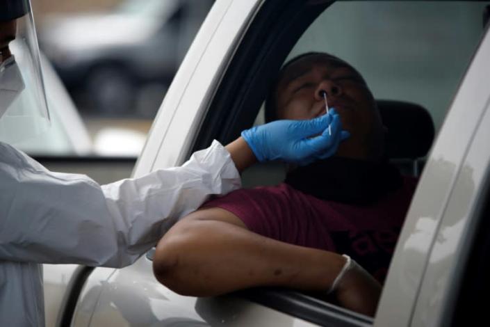 A health care worker administers a COVID-19 test at United Memorial Medical Center testing site in Houston, Texas -- now only the third state to register more than 10,000 virus cases in a 24-hour period (AFP Photo/Mark Felix)