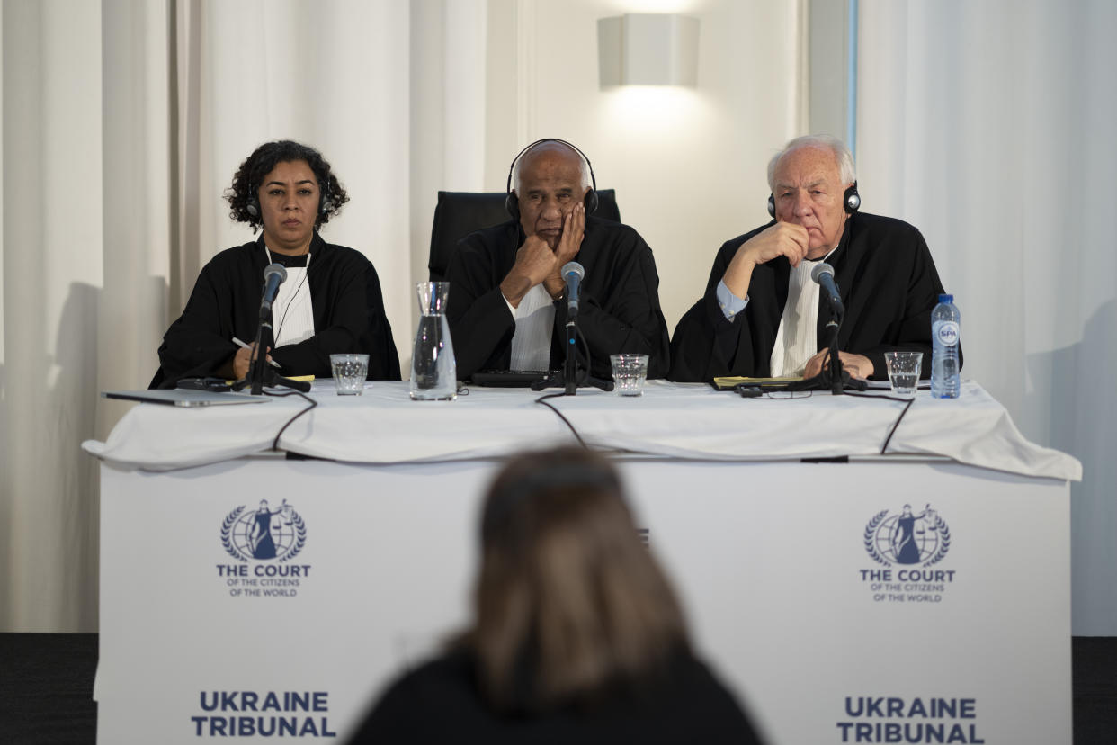 Judges Priya Pillai, left, Zak Yacoob, center, and Stephen Rapp, right, listen to the first witness of the 'people's tribunal' where prosecutors symbolically put Russian President Vladimir Putin on trial for the crime of aggression in Ukraine, in The Hague, Netherlands, Monday, Feb. 20, 2023. (AP Photo/Peter Dejong)