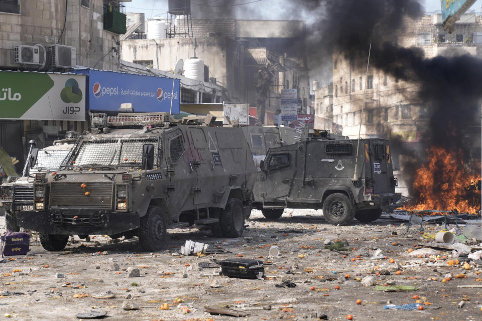 FILE - Smoke from fires fills the air as Palestinians clash with Israeli forces in the West Bank city of Nablus, Wednesday, Feb. 22, 2023. Israeli and Palestinian officials are meeting in the Egyptian resort town of Sharm el-Sheikh in a bid to ease tensions between the sides and rein in a spiral of violence ahead of a sensitive holiday period beginning this week. The meeting Sunday, March 19 was the second attempt by the sides, shepherded by regional allies Egypt and Jordan as well as the U.S., to end a year-long spasm of violence. (AP Photo/Majdi Mohammed)