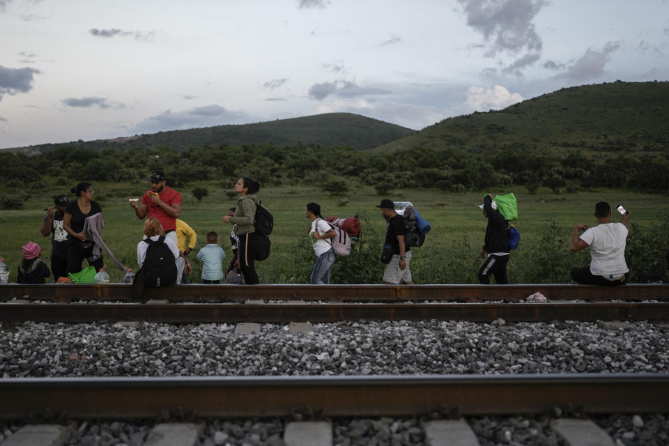 Migrants walk along a rail line hoping to board a freight train heading north, in Huehuetoca, Mexico, Sept. 19, 2023. Ferromex, Mexico's largest railroad company announced that it was suspending operations of its cargo trains due to the massive number of migrants that are illegally hitching a ride on its trains moving north towards the U.S. border. (AP Photo/Eduardo Verdugo)