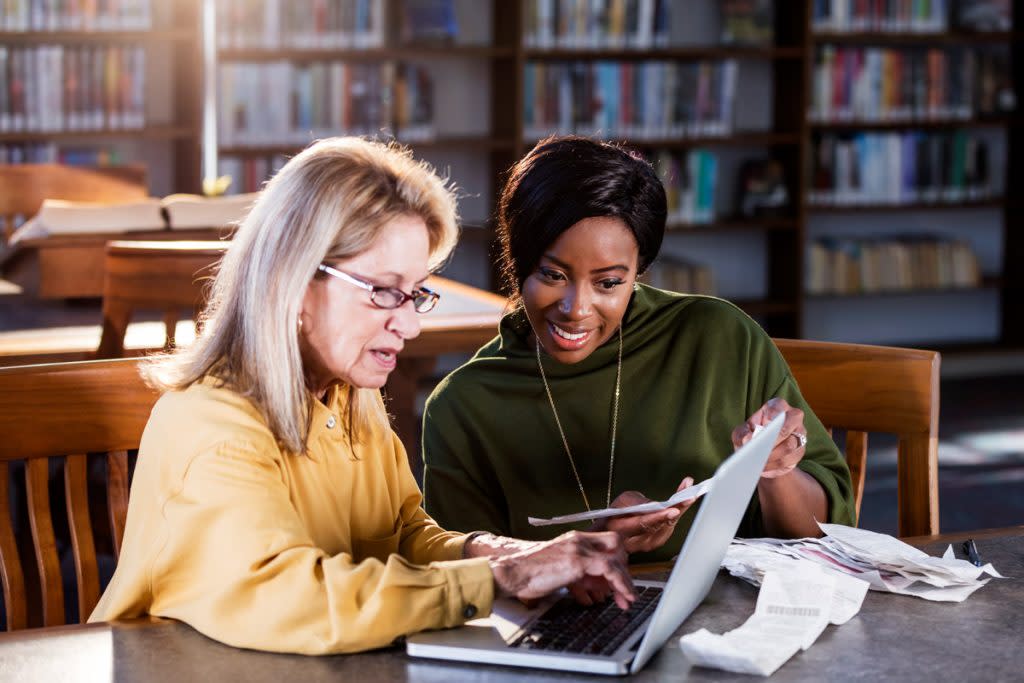 An older woman gets help with her taxes from the library. 