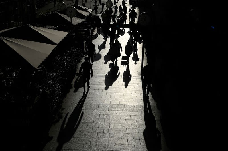 Workers walk through the Canary Wharf financial district in London