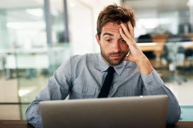 Shot of a businessman looking stressed while working at his desk in an office