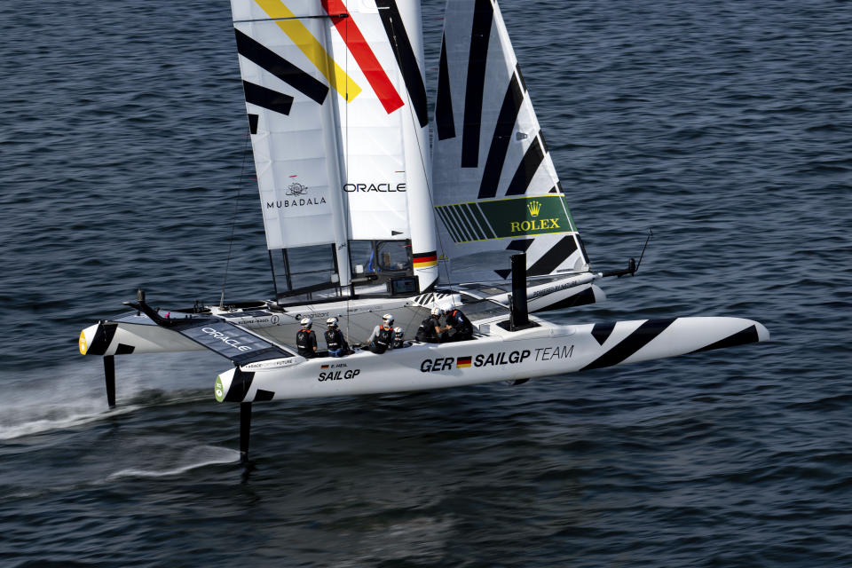 In this photo provided by SailGP, Sebastian Vettel, four-time Formula One world champion and investor of Germany SailGP Team, is at the wheel onboard the Germany SailGP Team F50 catamaran alongside Erik Heil, driver of Germany SailGP Team, as he takes part in the sixth sailor experience on Race Day 1 of the Oracle Los Angeles Sail Grand Prix at the Port of Los Angeles, Saturday, July 22, 2023. (Ricardo Pinto/SailGP via AP)