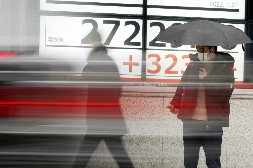 A person stands in front of an electronic stock board showing Japan's Nikkei 225 index at a securities firm Tuesday, Jan. 24, 2023, in Tokyo. Stocks were higher in Asia on Tuesday after a tech-led rally on Wall Street as investors bet the Federal Reserve will trim its rate hikes to tamp down inflation. (AP Photo/Eugene Hoshiko)