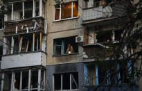 A resident looks out of a window of a damaged building after a rocket attack early Wednesday morning, in Kramatorsk, eastern Ukraine, Wednesday, Aug. 31, 2022. (AP Photo/Kostiantyn Liberov)