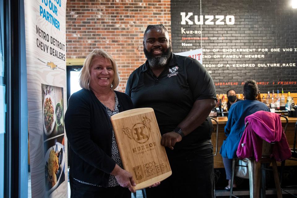 Free Press food writer Sue Selasky presents the Food Fighters award to Kuzzo's general manager Jeremiah Marion during the Detroit Free Press/Metro Detroit Chevy Dealers' Top 10 Takeover of Kuzzo's in Detroit in September 2021.