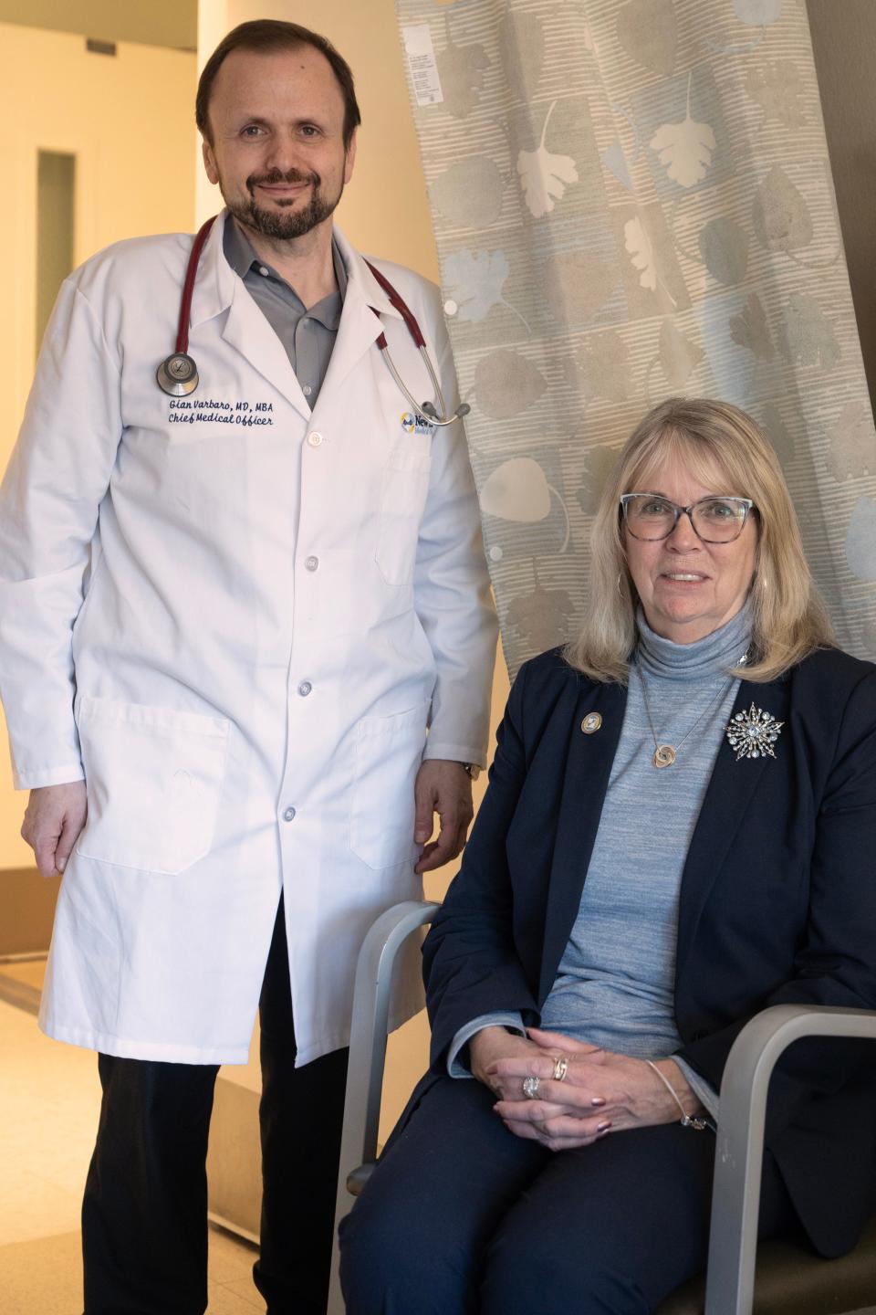 Barbara Piascik, an executive at Bergen New Bridge Medical Center, has long COVID. She has been advised by Dr. Gian Varbaro, at left, the hospital's chief medical officer.