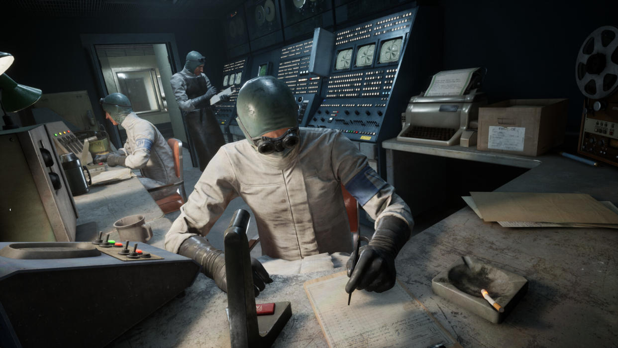  A scientist works at a desk, strewn with biometric machinery. 