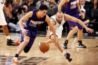 San Antonio Spurs shooting guard Manu Ginobili (R) tries to steal the ball from Phoenix Suns shooting guard Devin Booker (L) during the first half at AT&T Center. Mandatory Credit: Soobum Im-USA TODAY Sports