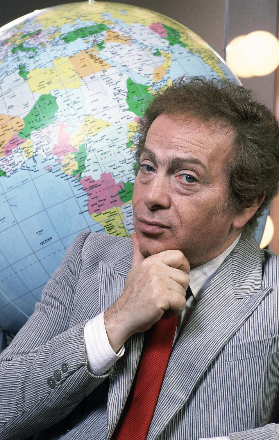 FILE - In this Jan. 27, 1987, file photo, Jackie Mason poses in his dressing with a globe as he stars in his own Broadway show in New York. Mason, a rabbi-turned-jokester whose feisty brand of standup comedy got laughs from nightclubs in the Catskills to West Coast talk shows and Broadway stages, has died. He was 93. Mason died Saturday, July 24, 2021, in Manhattan, the celebrity lawyer Raoul Felder told The Associated Press. (AP Photo/Carlos Rene Perez, File)