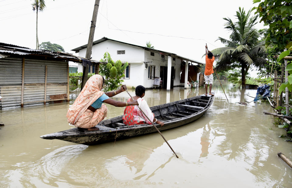 Villagers cross a flooded area on a boat, in Panikhaiti village, in Kamrup District, Assam, India on Tuesday, on July 14, 2020. Villages in Assam were flooded due to heavy rains. The rising water level inundated houses, residents were forced to move to a safer place. (Photo by Hafiz Ahmed/Anadolu Agency via Getty Images)