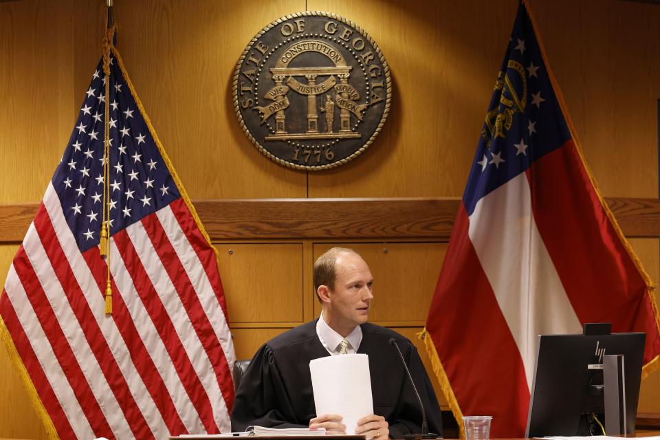 Fulton County Superior Court Judge Scott McAfee listens as motions are presented in his courtroom by an attorney for defendant Sidney Powell, in Atlanta, Thursday, Oct. 5, 2023. Nineteen people, including former President Donald Trump, were indicted in August and accused of participating in a wide-ranging illegal scheme to overturn the results of the 2020 presidential election. (Erik S. Lesser/Pool Photo, via AP)