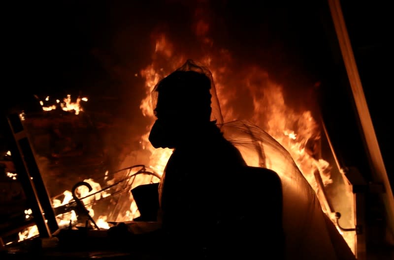 An anti-government protester is silhouetted during protests at Tsim Sha Tsui, in Hong Kong