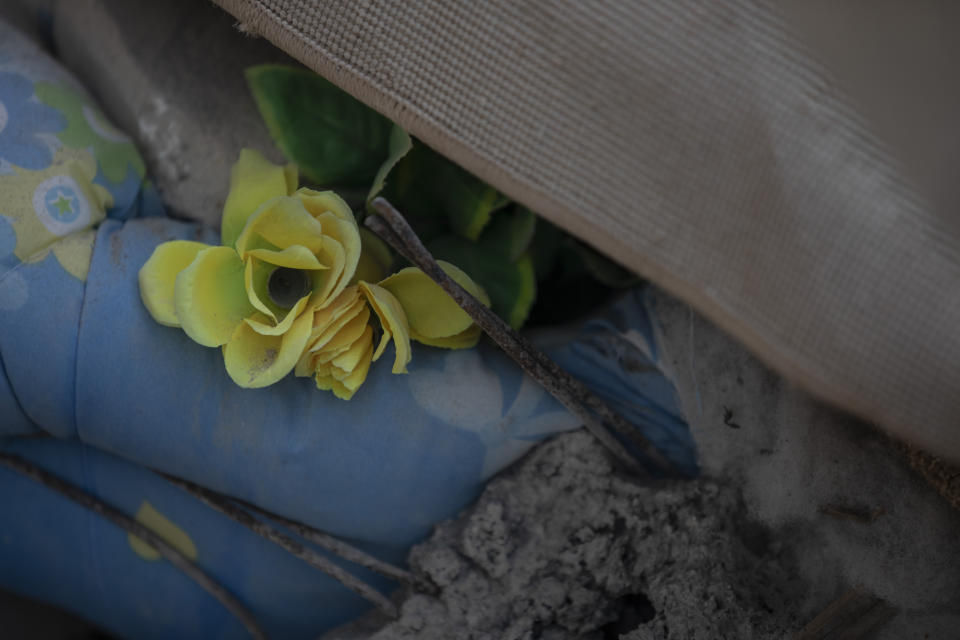 In this Wednesday, Nov. 27, 2019 photo, a plastic flower among rubbles of a collapsed building damage building in Thumane, western Albania following a deadly earthquake.(AP Photo/Petros Giannakouris)