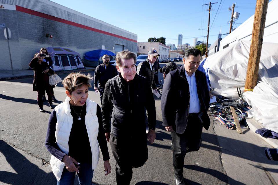 Estela Lopez, Executive Director of the Los Angeles Downtown Industrial Business Improvement District, left, walks with former baseball player Steve Garvey, center and Sergio Moreno during a visit to the Skid Row an area impacted most by homeless in Los Angeles, on Jan. 11, 2024. The candidacy for the U.S. Senate of former California baseball star Garvey has brought a splash of celebrity to the race that has alarmed his Democratic rivals and tugged at the state's political gravity. (AP Photo/Richard Vogel)