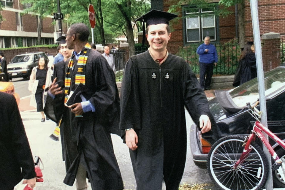 In this image provided by the Pete Buttigieg presidential campaign, Pete Buttigieg walks with his friend Uzo, left, to meet his parents before going ot his house graduation at Leverett House at his Harvard graduation on June 10, 2004 in Cambridge, Mass. (Pete Buttigieg Presidential Campaign via AP)